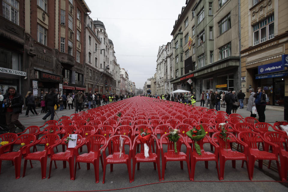 Red chairs are displayed along a main street in Sarajevo as the city marks the 20th anniversary of the start of the Bosnian war on Friday, April,6, 2012. City officials have lined up 11,541 red chairs arranged in 825 rows along the main street that now looks like a red river representing the 11,541 Sarajevans who were killed during the siege.(AP Photo/Amel Emric)