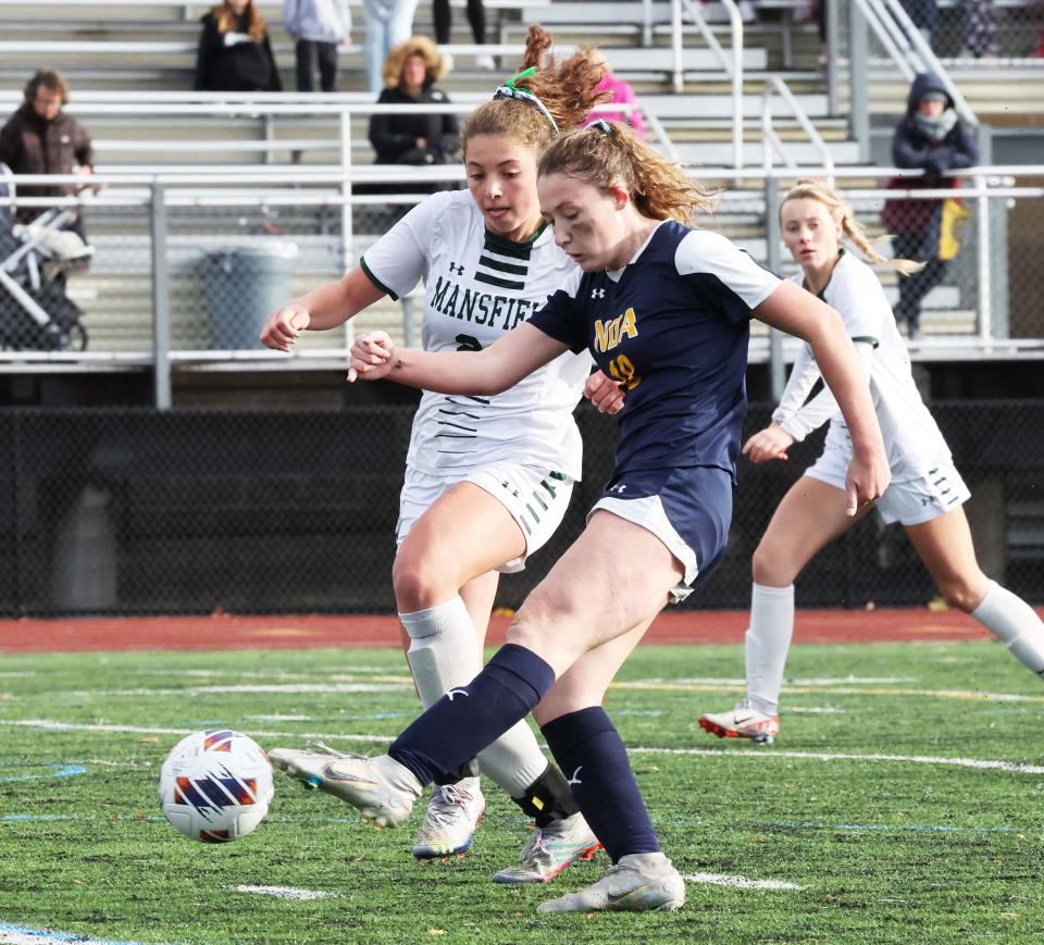 Notre Dame Academy's Sydney Comeau scores the winning goal, eluding Mansfield's Emma McPherson, in the Div. 2 state final in Lynn on Saturday, Nov. 18, 2023.