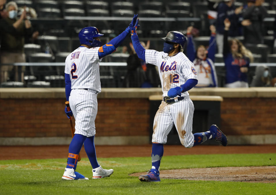 New York Mets' Francisco Lindor (12) is congratulated by Dominic Smith (2) after scoring against the Arizona Diamondbacks during the third inning of a baseball game Saturday, May 8, 2021, in New York. (AP Photo/Noah K. Murray)