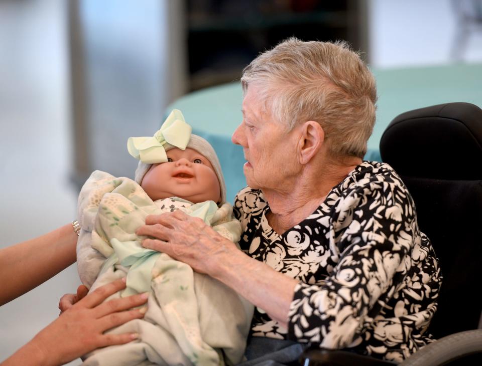 Resident Shirley Allen receives a doll at Glenwood Care and Rehabilitation. The Canton facility hosted a "baby shower" for its memory-care residents.