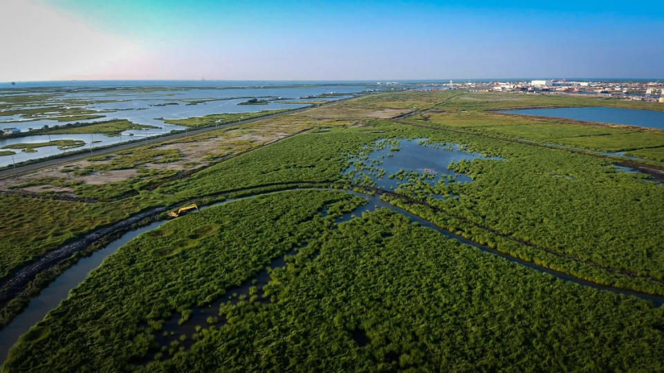 An aerial view shows Port Fourchon's Coastal Wetlands Park, 100 acres of wetlands built with soil dredged to make a waterway for the port. The park includes a manmade tidal creek suitable for kayaking, paddleboarding, recreational fishing and birdwatching.