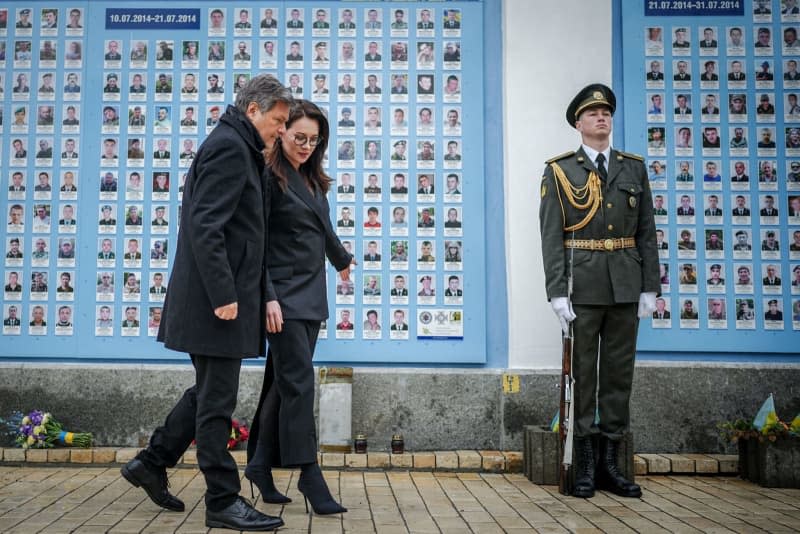 German Minister for Economic Affairs and Climate Protection Robert Habeck (L) lays flowers at the memorial wall for the soldiers who died in the war. Kay Nietfeld/dpa