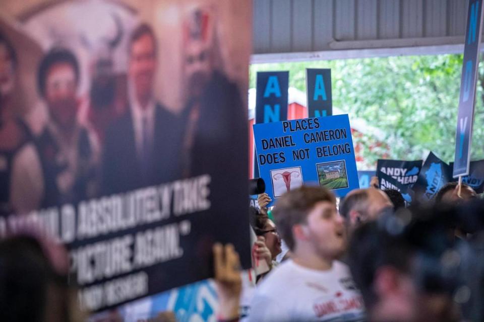 People hold signs and cheer during the annual St. Jerome Fancy Farm Picnic in Fancy Farm, Ky., on Saturday, Aug. 5, 2023.