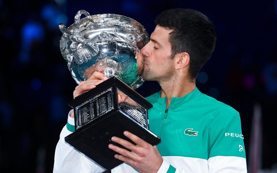 It's a familiar end to the Australian Open, as Novak Djokovic kisses the trophy for the ninth time - AFP