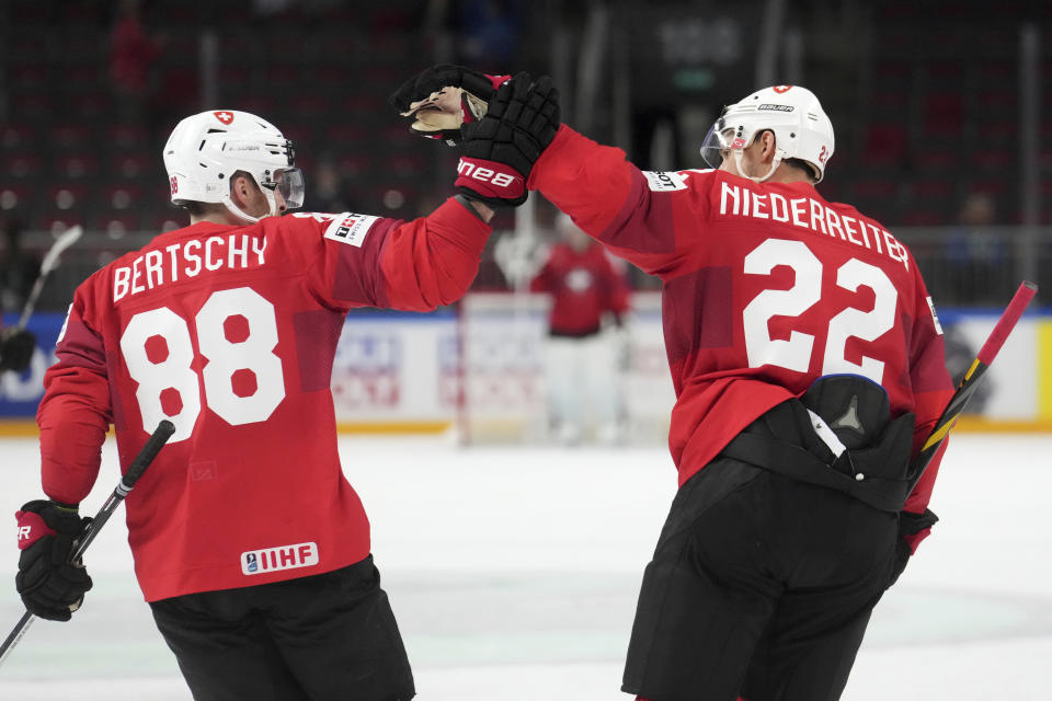 Nino Niederreiter, right, and Christoph Bertschy, left, of Switzerland celebrate a goal during the group B match between Norway and Switzerland at the ice hockey world championship in Riga, Latvia, Sunday, May 14, 2023. (AP Photo/Roman Koksarov)