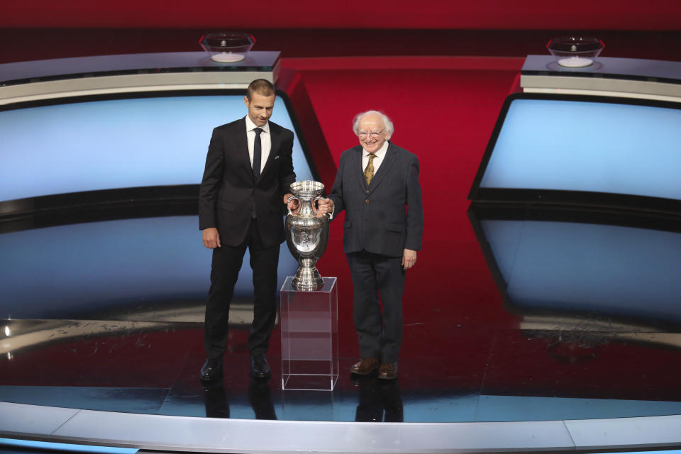 UEFA President Aleksander Ceferin and the President of Ireland Michael D. Higgins hold the trophy during the UEFA Euro 2020 European soccer championship qualifying draw at the Convention Centre in Dublin, Ireland, Sunday, Dec. 2, 2018. (AP Photo/Peter Morrison)