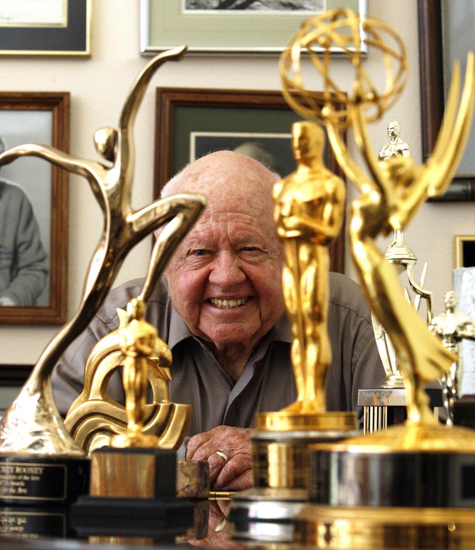Actor Mickey Rooney smiles in front of his trophies during an interview with Reuters at his home in Westlake Village, California in this February 14, 2007 file photo. Rooney, the pint-sized screen dynamo of the 1930s and 1940s best known for his boy-next-door role in the Andy Hardy movies, died on April 6, 2014 at 93, the TMZ celebrity website reported. It did not give a cause of death and a spokesman was not immediately available for comment. REUTERS/Mario Anzuoni/Files (UNITED STATES - Tags: ENTERTAINMENT OBITUARY)
