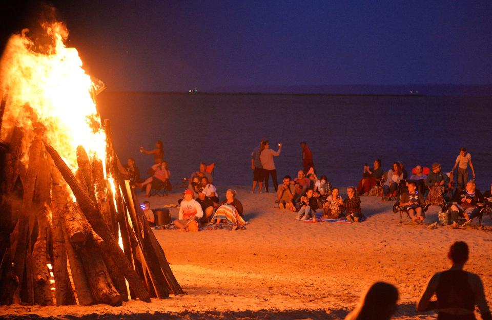 People watch the giant bonfire on July 24, 2021, at Presque Isle State Park's Beach 11 in Millcreek Township during Discover Presque Isle.