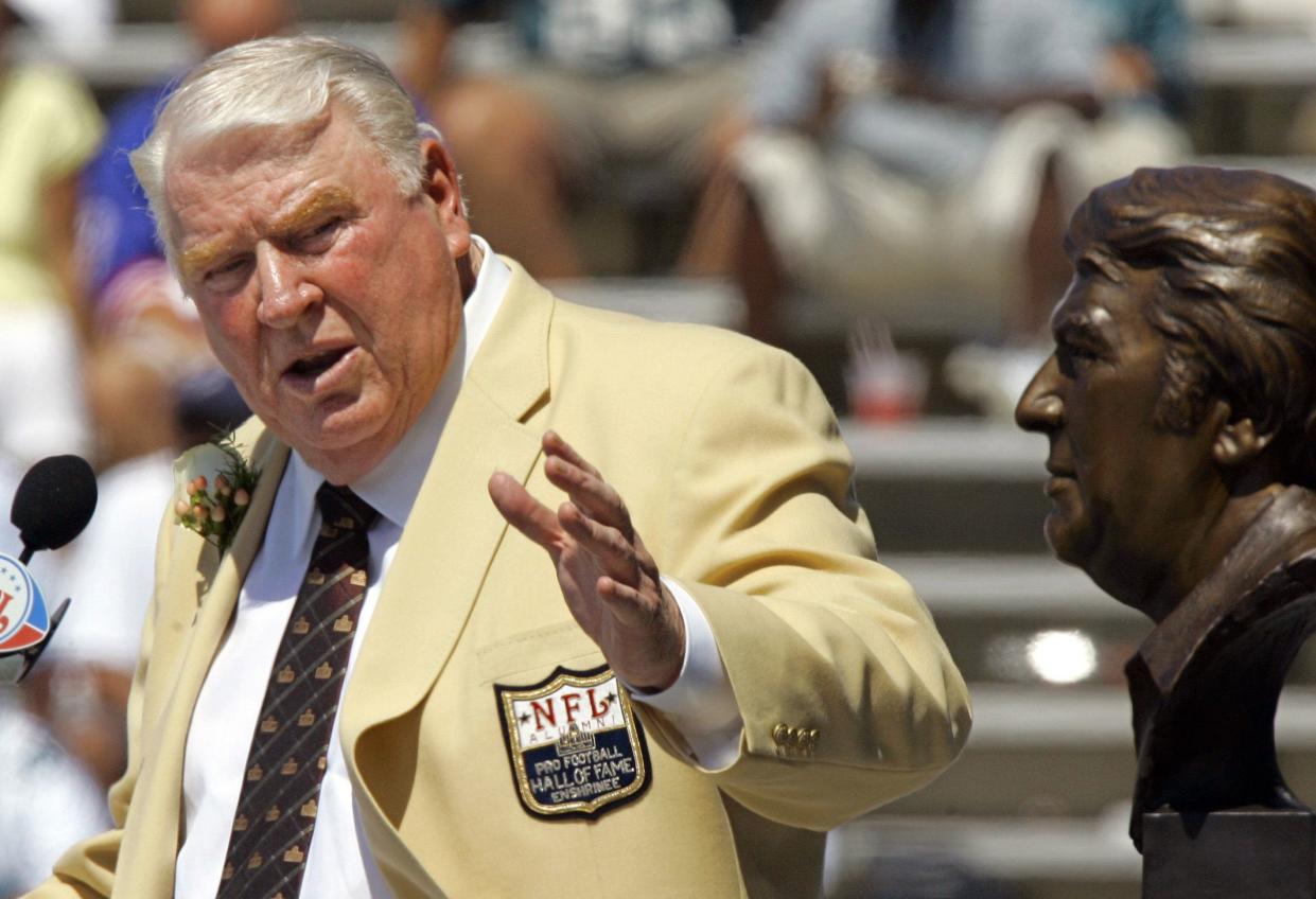 Former Oakland Raiders coach John Madden gestures toward a bust of himself during his enshrinement into the Pro Football Hall of Fame in Canton, Ohio, on Aug. 5, 2006.