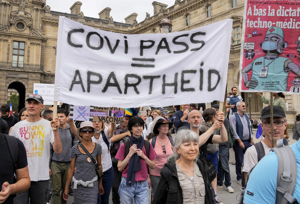 Anti-vaccine protesters march with a banner during a rally in Paris, Saturday, July 17, 2021. A Holocaust survivor, French officials and anti-racism groups are denouncing anti-vaccination protesters who are comparing themselves to Jews persecuted by the Nazis. Some mostly far-right demonstrators at weekend protests against government vaccine rules wore yellow stars, like those Jews were forced to wear under Nazi rule in World War II. Other demonstrators carried signs evoking the Auschwitz death camp or South Africa's apartheid regime, claiming the French government is unfairly persecuting them as it battles the pandemic. (AP Photo/Michel Euler, File)