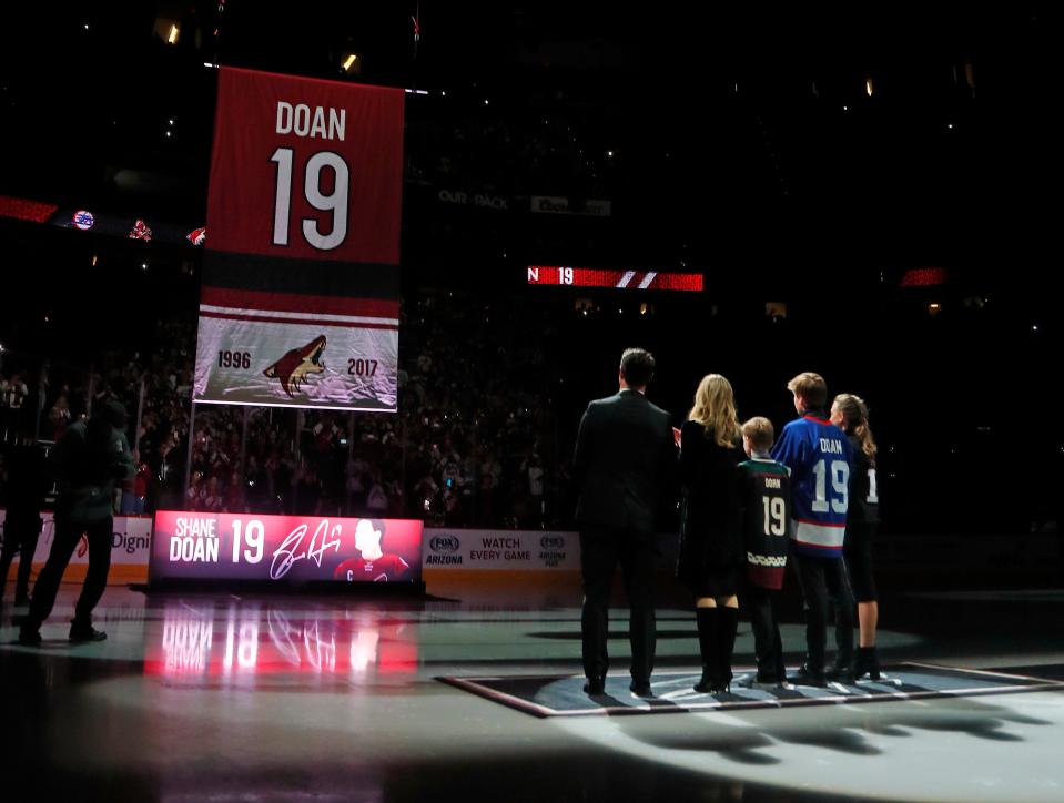 Shane Doan (L-R) stands with his wife Andrea Doan, and children Carson, Josh and Karys as the 19 from his jersey ascends to the rafters during a jersey retirement ceremony for Shane Doan at Gila River Arena in Glendale, Ariz. on February 24, 2019. 