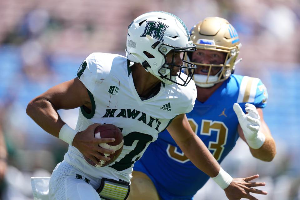 Chevan Cordeiro is pressured by Bo Calvert in the first half at the Rose Bowl. UCLA beat Hawaii 44-10.