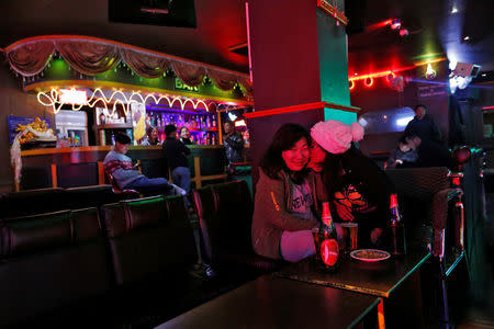 Women share a joke in a Karaoke bar in the capital city of Thimphu, Bhutan, December 16, 2017. REUTERS/Cathal McNaughton