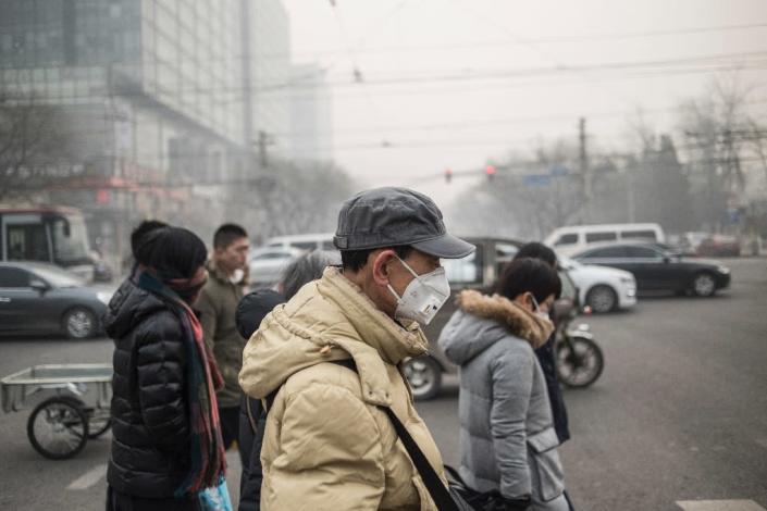 Pedestrians wear masks on a polluted day in Beijing on November 30, 2015 (AFP Photo/Fred Dufour)