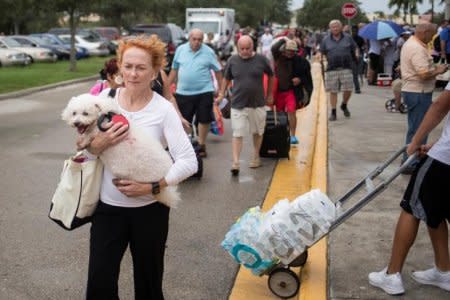 FILE PHOTO: Residents carry their pets and belongings into a shelter ahead of the downfall of Hurricane Irma in Estero, Florida, U.S. September 9, 2017. REUTERS/Adrees Latif