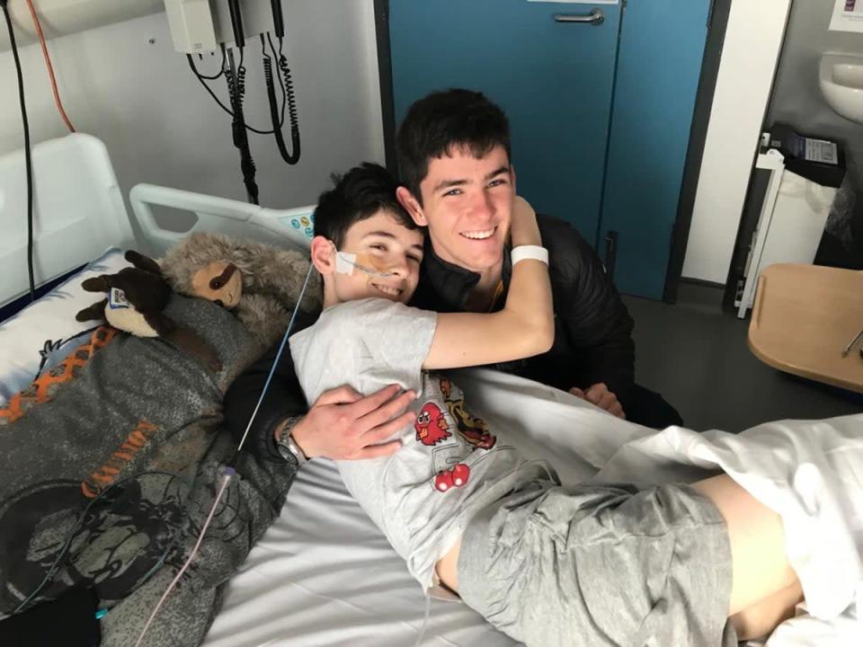 Daniel Greer y su hermano James se abrazan en el hospital (folleto familiar)