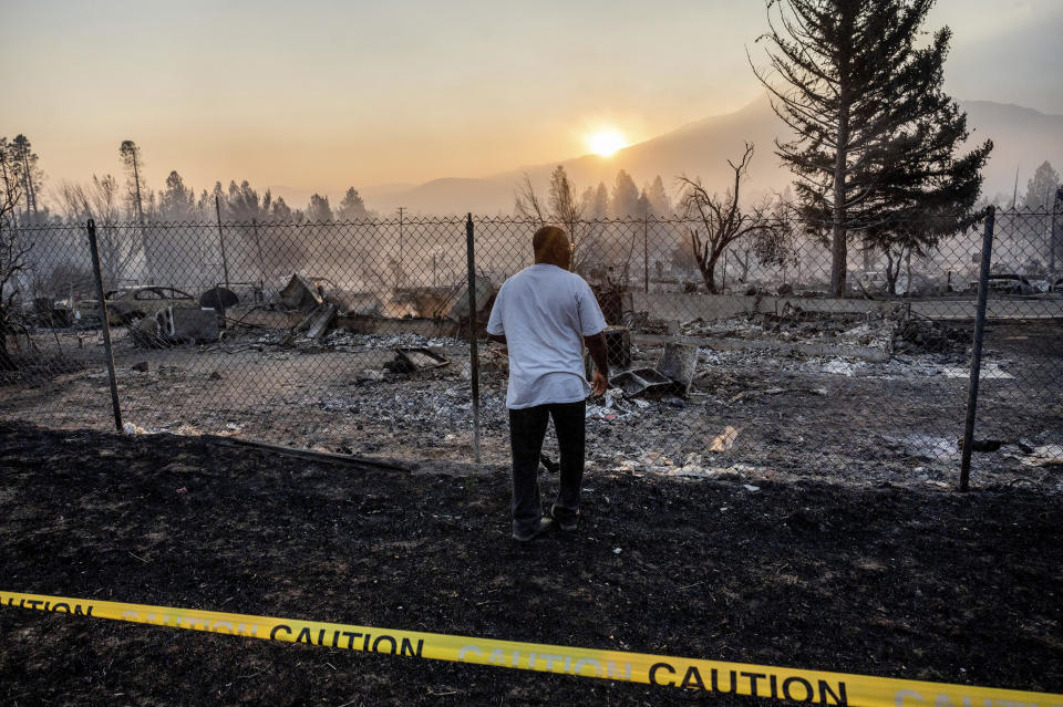 Dave Rodgers surveys his home, destroyed by the Mill Fire, on Saturday, Sept. 3, 2022, in Weed, Calif. Rodgers, who lived in the house his entire life, was able to take an elderly neighbor with him as he fled the fast-moving blaze but has not been able to find his two dogs that were left behind. (AP Photo/Noah Berger)