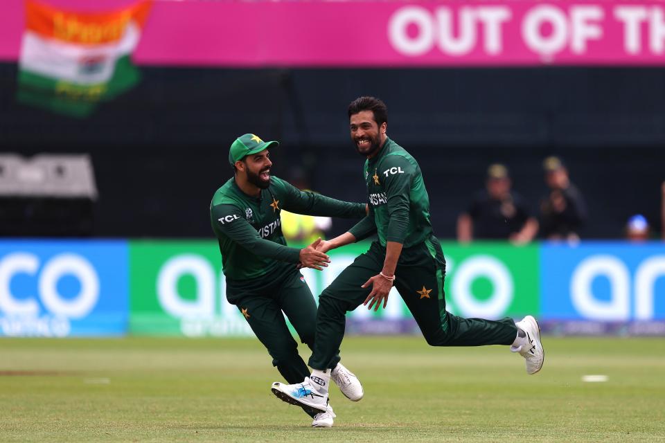 Mohammad Amir of Pakistan celebrates with teammate Shadab Khan of Pakistan after dismissing Ravindra Jadeja of India during the ICC Men's T20 Cricket World Cup match between India and Pakistan at Nassau County International Cricket Stadium on June 09, 2024 in New York.