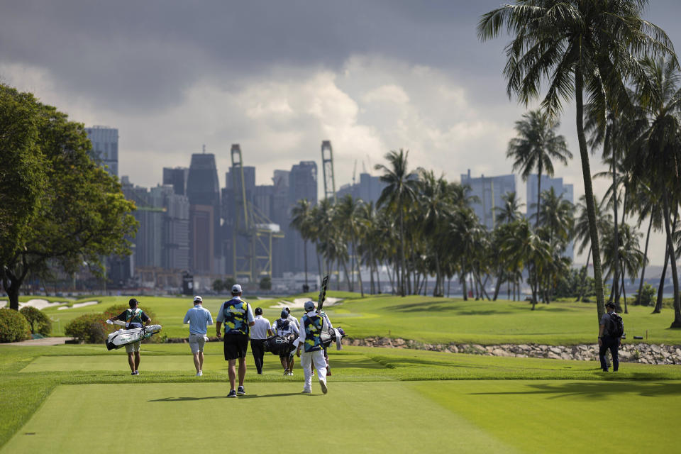 Joaquín Niemann, Patrick Reed and Branden Grace walk toward the fifth green during the first round of LIV Golf Singapore at Sentosa Golf Club on Friday, April 28, 2023, on Sentosa Island in Singapore. (Doug DeFelice/LIV Golf via AP)