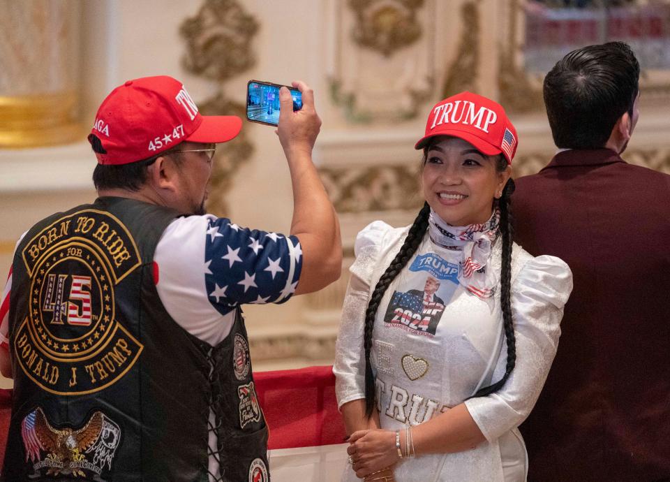 Supporter Binh Vo takes a photo of his wife Trang Ngoc at a Super Tuesday watch party for former president Donald Trump at Mar-a Lago on March 5, 2024 in Palm Beach.