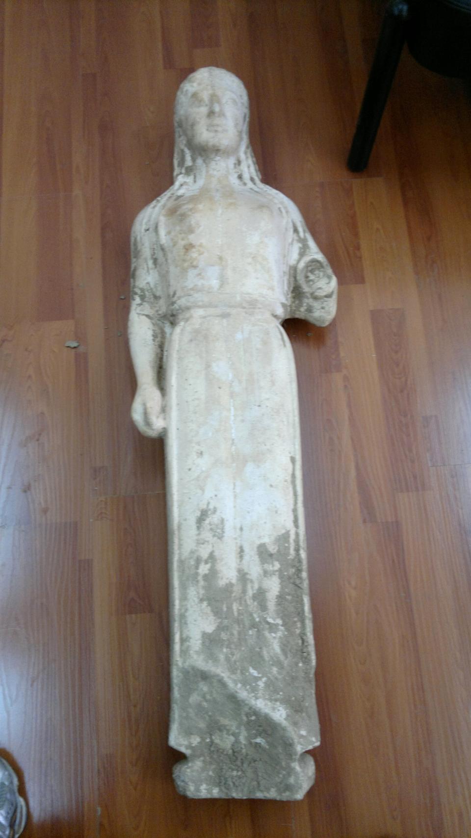 A 2,500-year-old statue of a young woman that was illegally excavated and hidden in a goat-pen near Athens is seen in this undated police handout photo released on Wednesday, March 28, 2012. Officers arrested the goatherder and another man who were allegedly trying to sell the work for half a million euros ($667,000). A police statement said the marble statue dates to about 520 B.C. and belongs to the kore type. It is largely intact, lacking the left forearm and plinth. (AP Photo/Greek Police handout)