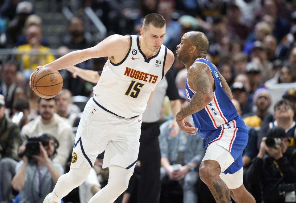 Denver Nuggets center Nikola Jokic, left, drives into Philadelphia 76ers forward P.J. Tucker in the first half of an NBA basketball game, Monday, March 27, 2023, in Denver. (AP Photo/David Zalubowski)