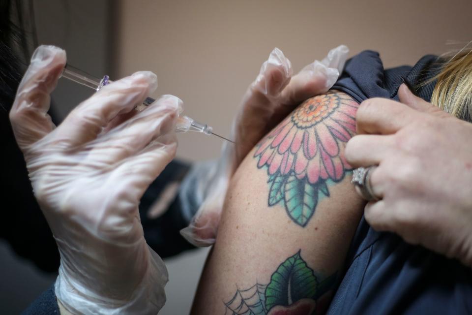 Pharmacist Mindy Howard gives Jennifer Cantrell, pharmacy tech, her second dose of the Hepatitis A vaccine inside Med Zone Pharmacy in Prestonsburg, Ky. on Jan. 9, 2019. Since a statewide outbreak of Hep A was declared in November 2017, the state has had more than 3,500 cases and 22 deaths.