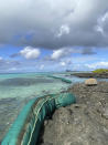 In this photo provided by Grégoire Rouxel a ship, top right, off shore that ran aground is leaking fuel in the ocean, Friday, Aug. 7, 2020, in Mauritius. The Indian Ocean island of Mauritius has declared a "state of environmental emergency" after a Japanese-owned ship that ran aground offshore days ago began spilling tons of fuel. Prime Minister Pravind Jugnauth announced the development late Friday, Aug. 7, as satellite images showed a dark slick spreading near environmental areas the government called "very sensitive." (@gregrouxel via AP)