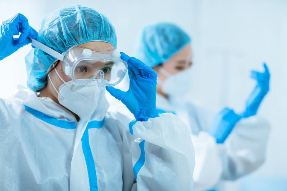 female medical worker wear protective suits and ready to take care of coronavirus patient in isolation room