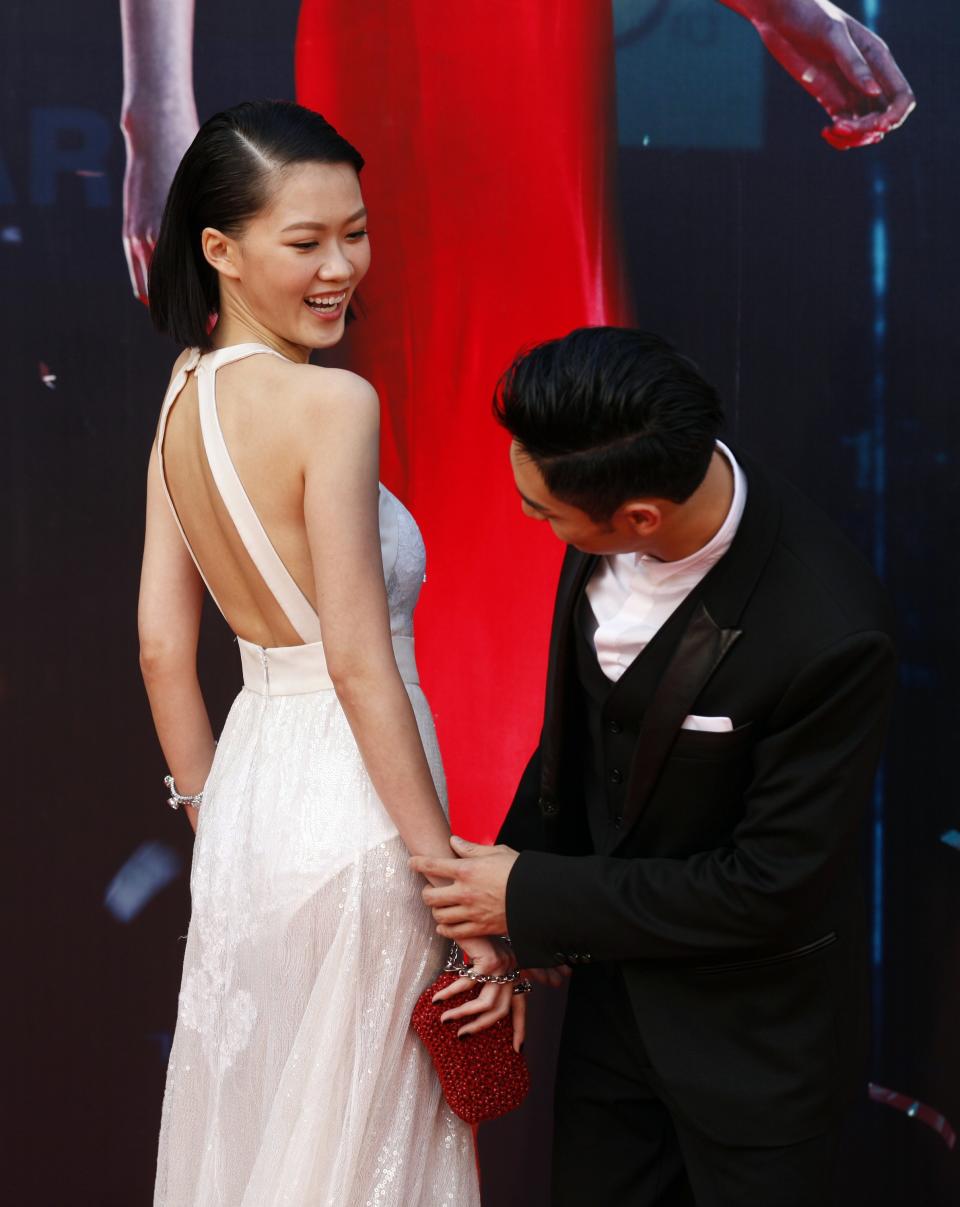 Hong Kong actor Kwan and Malaysian actress Liew laugh while posing on red carpet during 33rd Hong Kong Film Awards in Hong Kong