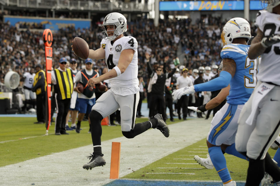 Oakland Raiders quarterback Derek Carr scores against the Los Angeles Chargers during the first half of an NFL football game Sunday, Dec. 22, 2019, in Carson, Calif. (AP Photo/Marcio Jose Sanchez)