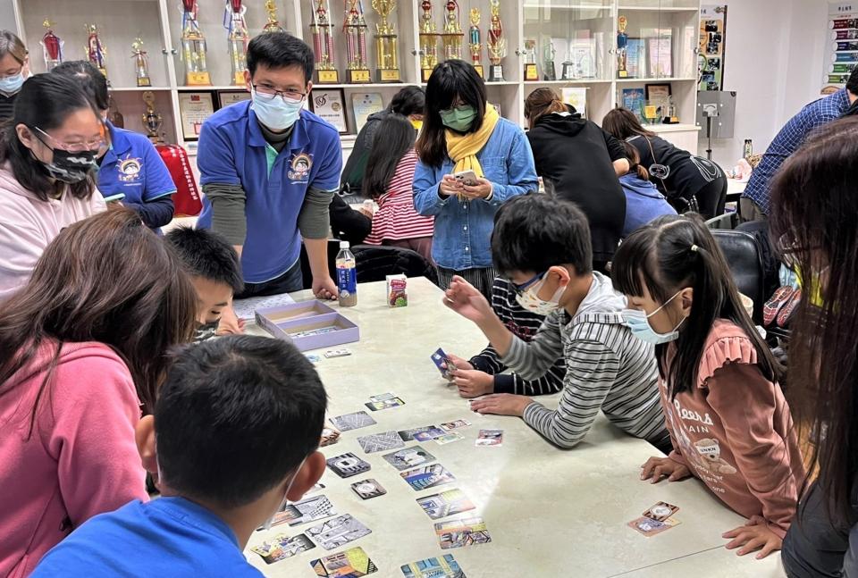 輔導團教師引導親子進行桌遊，學生與家長皆摩拳擦掌、避開危險破關