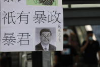A defaced poster of Chinese President Xi Jinping with part of a message that reads "There are no rioters, there is only trranny," stands on a new Lennon Wall in Hong Kong, Saturday, Sept. 28, 2019. Hong Kong activists first created their own Lennon Wall during the 2014 protests, covering a wall with a vibrant Post-it notes calling for democratic reform. Five years later, protestors have gathered to create impromptu Lennon Walls across Hong Kong island. (AP Photo/Vincent Thian)
