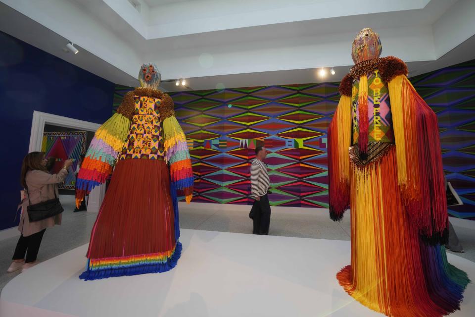 Visitantes miran esculturas del artista Jeffrey Gibson en el pabellón estadounidense en la 60a Bienal de Artes en Venecia, Italia, el martes 16 de abril de 2024. Gibson, un choctaw de Mississippi de ascendencia cherokee, es el primer indígena estadounidense en representar a Estados Unidos en solitario en la Bienal de Venecia, la muestra de arte contemporáneo más antigua del mundo. (Foto AP/Luca Bruno) (AP Photo/Luca Bruno)