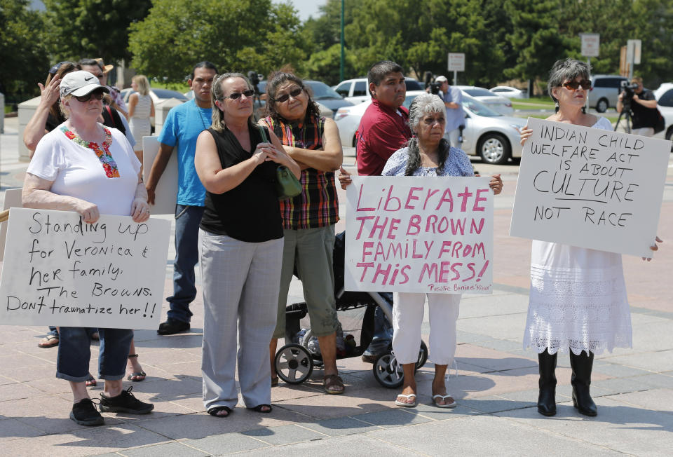 FILE - Participants listen during a rally in support of three-year-old baby Veronica, Veronica's biological father, Dusten Brown, and the Indian Child Welfare Act, in Oklahoma City, Monday, Aug. 19, 2013. Brown is trying to maintain custody of the girl who was given up for adoption by her birth mother to Matt and Melanie Capobianco of South Carolina. The U.S. Supreme Court will hear arguments, Wednesday, Nov. 9, 2022 on the most significant challenge to the Indian Child Welfare Act that gives preference to Native American families in foster care and adoption proceedings of Native American children since it passed in 1978. (AP Photo/Sue Ogrocki, File)