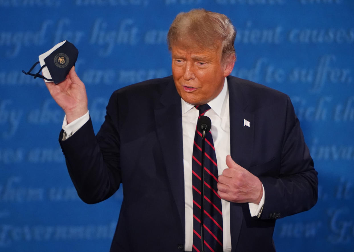 U.S. President Donald Trump holds a protective mask during the first U.S. presidential debate hosted by Case Western Reserve University and the Cleveland Clinic in Cleveland, Ohio, U.S., on Tuesday, Sept. 29, 2020. (Kevin Dietsch/UPI/Bloomberg via Getty Images)