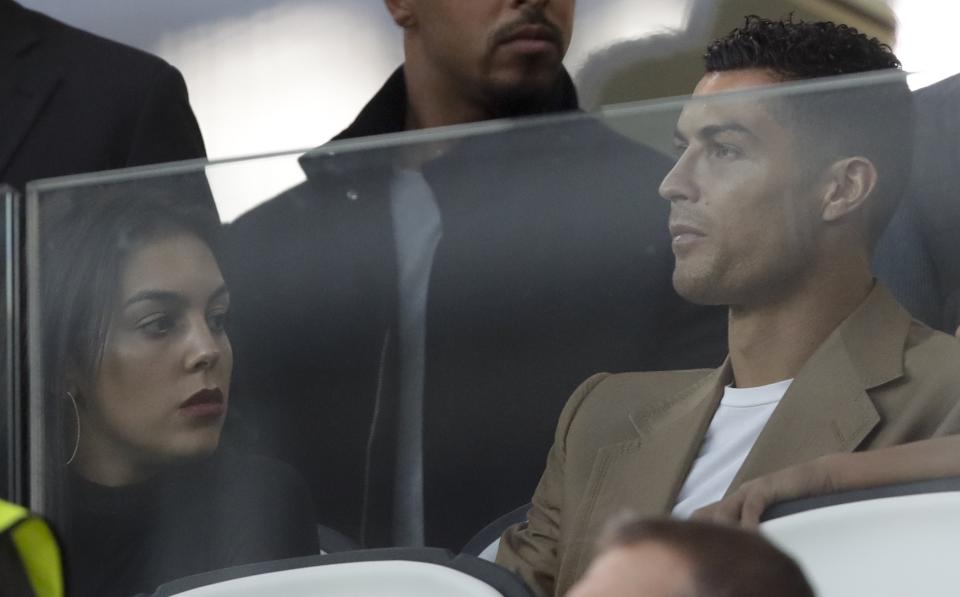 El delantero de la Juventus Cristiano Ronaldo y su pareja Georgina en la tribuna previo al partido contra Young Boys en la Liga de Camoeones, en el estadio Allianza de Turín, el martes 2 de octubre de 2018. (AP Foto/Luca Bruno)