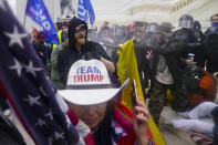 FILE - In this Wednesday, Jan. 6, 2021 file photo Trump supporters try to break through a police barrier at the Capitol in Washington. As Congress prepared to affirm President-elect Joe Biden's victory, thousands of people gathered to show their support for President Donald Trump and his claims of election fraud. British Prime Minister Boris Johnson has said a lot of nice things about Donald Trump over the years, from expressing admiration for the U.S. president to suggesting he might be worthy of the Nobel Peace Prize. But after a mob of Trump supporters invaded the U.S. Capitol on Jan. 6, Johnson has changed his tune.(AP Photo/John Minchillo, File)