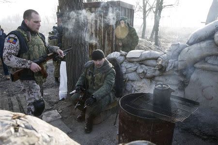 Members of the armed forces of the separatist self-proclaimed Donetsk People's Republic rest at a checkpoint near Donetsk, February 15, 2015. REUTERS/Baz Ratner