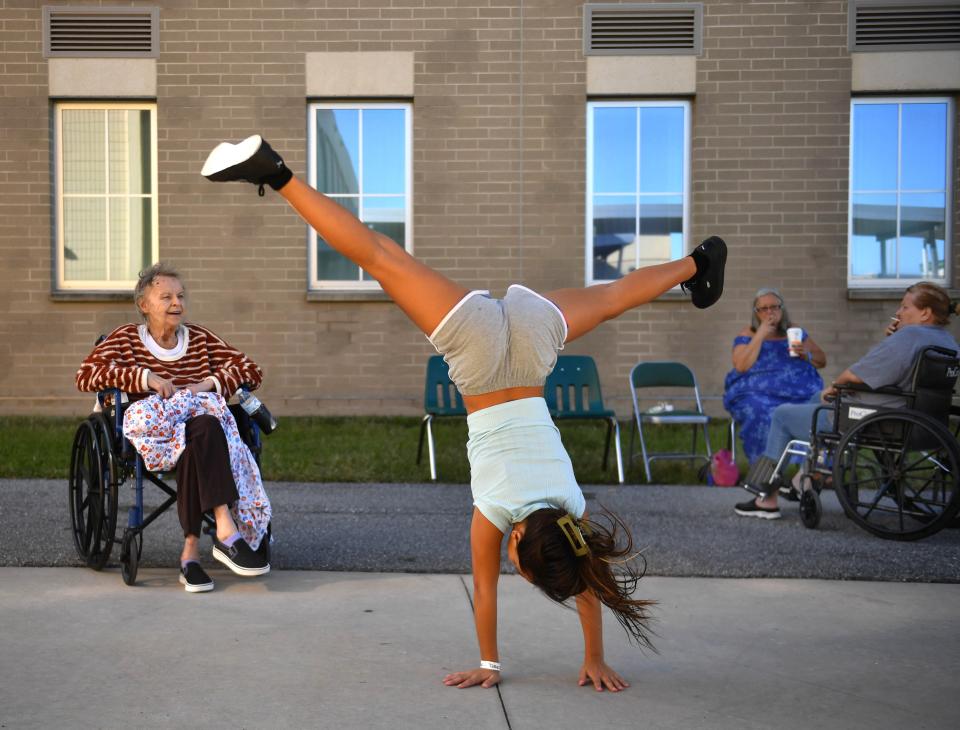 Saphira Torres, 12, from North Port, performs a cartwheel to entertain Patricia Johns, also from North Port on Monday morning, Oct. 3, 2022 at the Venice High hurricane shelter in Venice, Florida, following Hurricane Ian. Torres evacuated to the shelter with her mom, brother and sister. Johns, who had to be evacuated by airboat, said, "It was the first time I had to do that in my life - and the last."