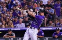 Aug 11, 2018; Denver, CO, USA; Colorado Rockies third baseman Ryan McMahon (24) hits a single during the seventh inning of game against the Los Angeles Dodgers at Coors Field. Mandatory Credit: Troy Babbitt-USA TODAY Sports