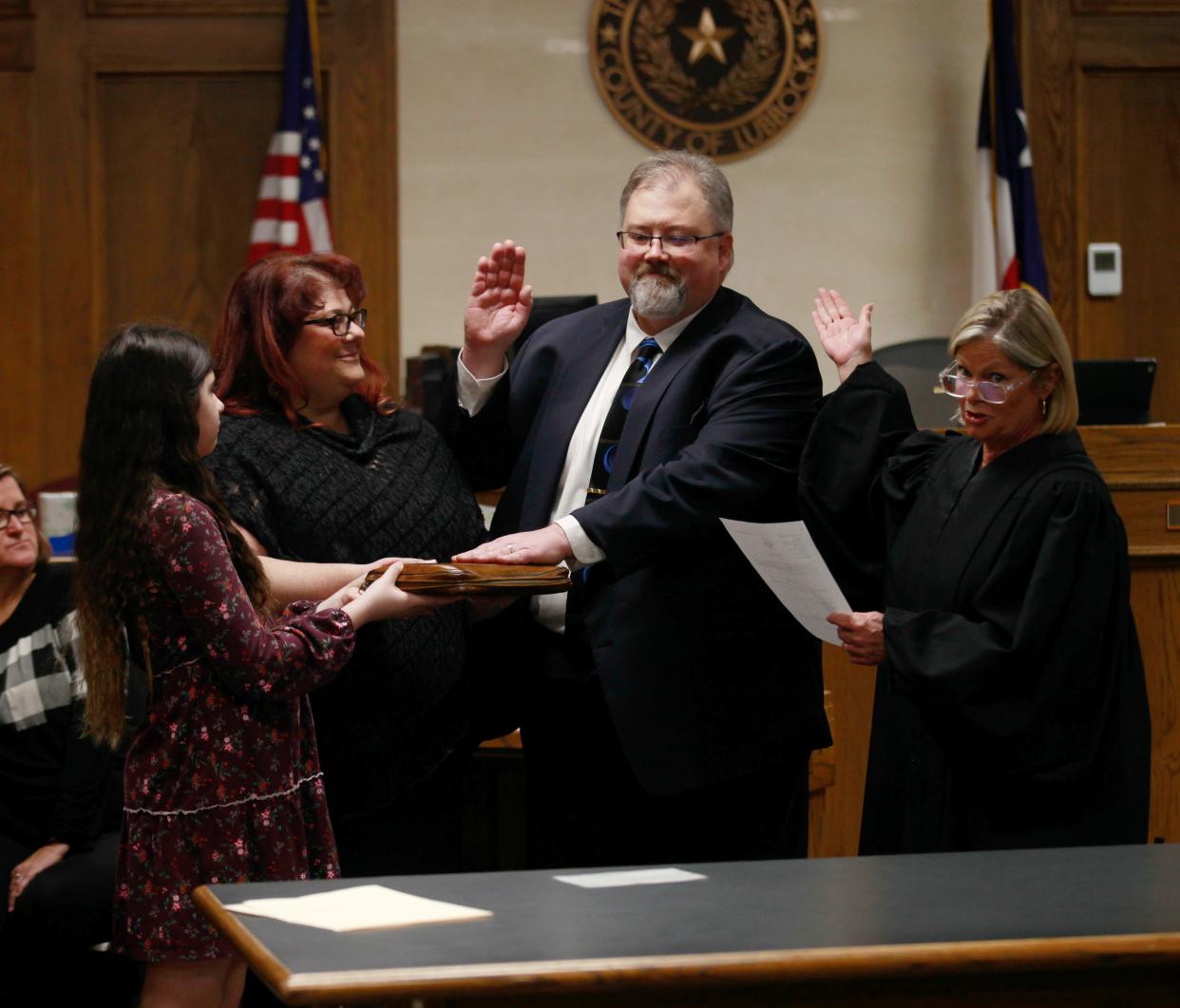 Former prosecutor Tom Brummett, center, is sworn in as judge of Lubbock County Court at Law #2 by outgoing judge Drue Farmer on Tuesday.
