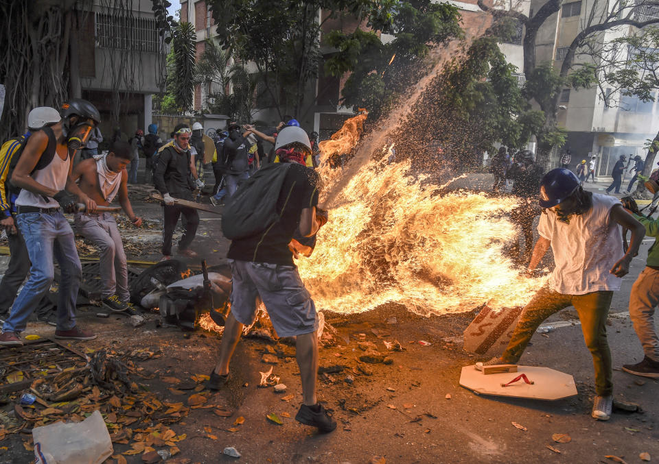 <p>Demonstrator catches fire: Víctor Salazar catches fire after a motorcycle explodes, during a street protest is Caracas, Venezuela, May 3, 2017.<br>José Víctor Salazar Balza (28) caught fire after the gas tank on a motorcycle exploded, during a protest against the Venezuelan president, Nicolás Maduro, in Caracas. Violent clashes had broken out between demonstrators and the national guard. The motorcycle, belonging to a member of the national guard, was apparently being destroyed by protesters.<br>Accounts of the incident differ, but some say that an object thrown by protesters caused the gas tank to explode. Further reports maintain that Salazar’s clothing caught fire so readily because he was doused in petrol either by a bomb he was carrying, or that of a fellow protestor.<br>Salazar suffered severe burns to more than 70% of his body, but survived the incident. (Photo: Juan Barreto/AFP) </p>