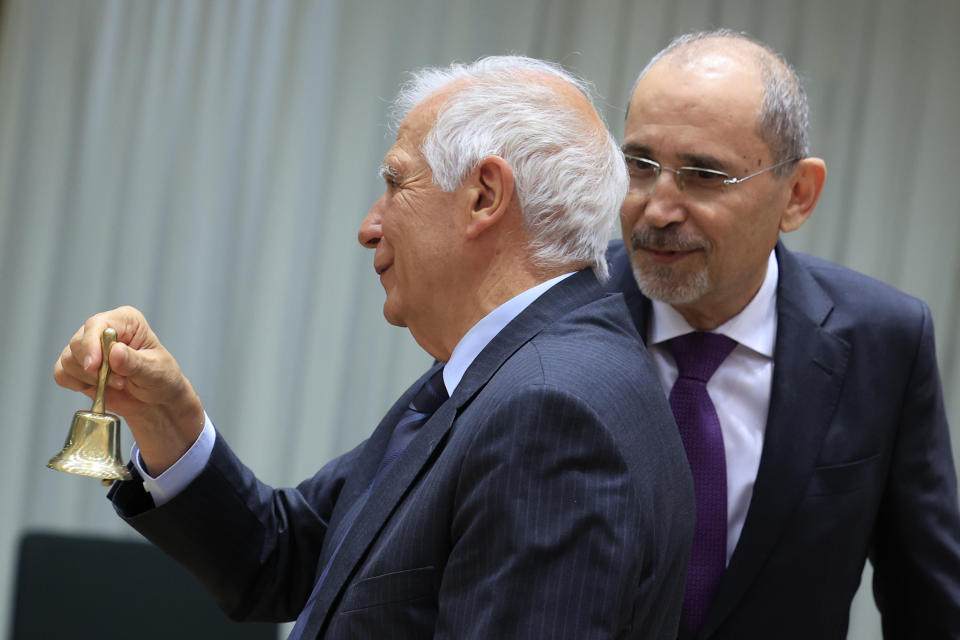 European Union foreign policy chief Josep Borrell, left, rings a bell to signify the start of a meeting as he speaks with Jordan's Minister of Foreign Affairs Ayman Safadi at the European Council building in Brussels, Monday, May 27, 2024. Ministers meet Monday for the eighth Brussels Conference on "Supporting the future of Syria and the region". (AP Photo/Geert Vanden Wijngaert)