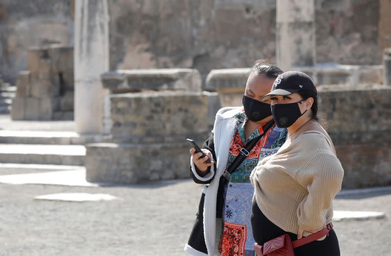 Tourists wearing masks visit the ruins of the ancient Roman city of Pompeii