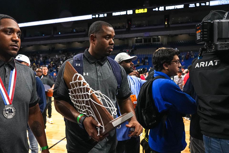 Stony Point basketball coach Antoine Thompson holds the UIL runner-up trophy after the Tigers lost 53-41 to Plano East in the   Class 6A championship game. The Tigers finished 38-2 in Thompson's second season are are 70-4 in his first two years.