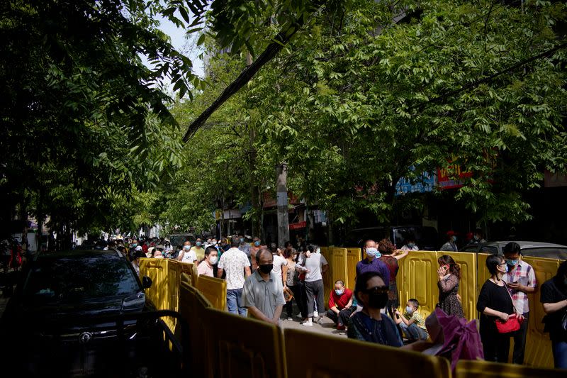 Residents wearing face masks line up for nucleic acid testings at a residential compound in Wuhan