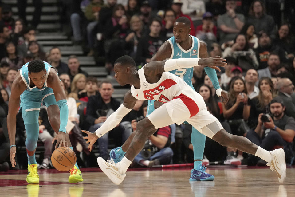 Charlotte Hornets forward Brandon Miller, left, vies for control of the ball with Toronto Raptors guard Dennis Schroder, front right, during first-half NBA basketball game action in Toronto, Monday, Dec. 18, 2023. (Nathan Denette/The Canadian Press via AP)