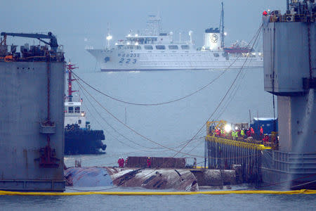 The sunken ferry Sewol is raised during its salvage operations on the sea off Jindo, South Korea, March 23, 2017. Yonhap via REUTERS