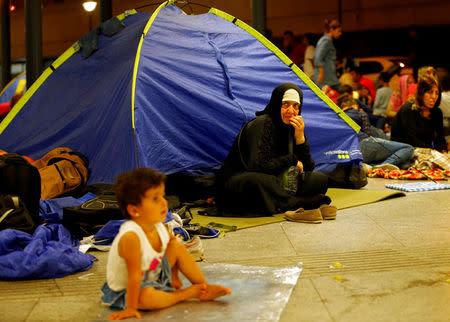 FILE PHOTO: Asylum seekers wait outside a train station in Budapest, Hungary, August 28, 2015. REUTERS/Laszlo Balogh/File Photo